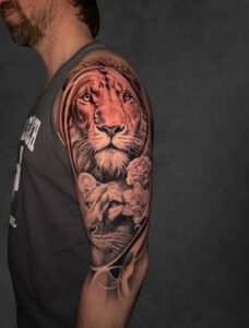 Black and grey lion portrait realism tattoo on upper arm — Undertone Tattoos Mohali